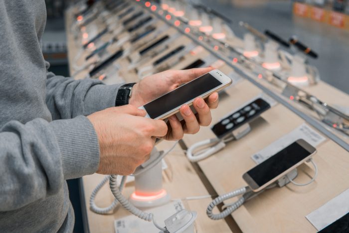 Closeup,View,Of,Male,Customer,Hands,,Choosing,White,Smartphone,In best-selling-smartphones-of-Q1-2022